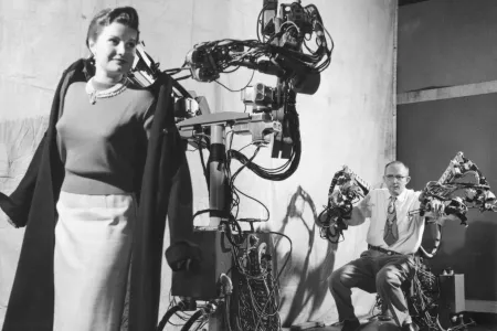 Man doet vrouw jas aan met aankleedrobot.