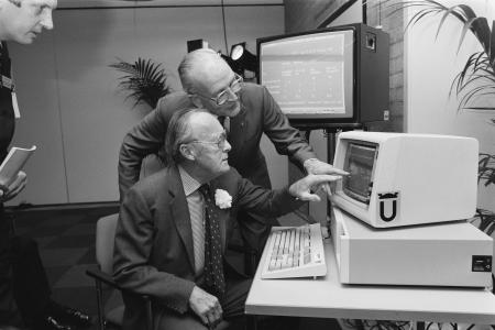 Two men behind a computer